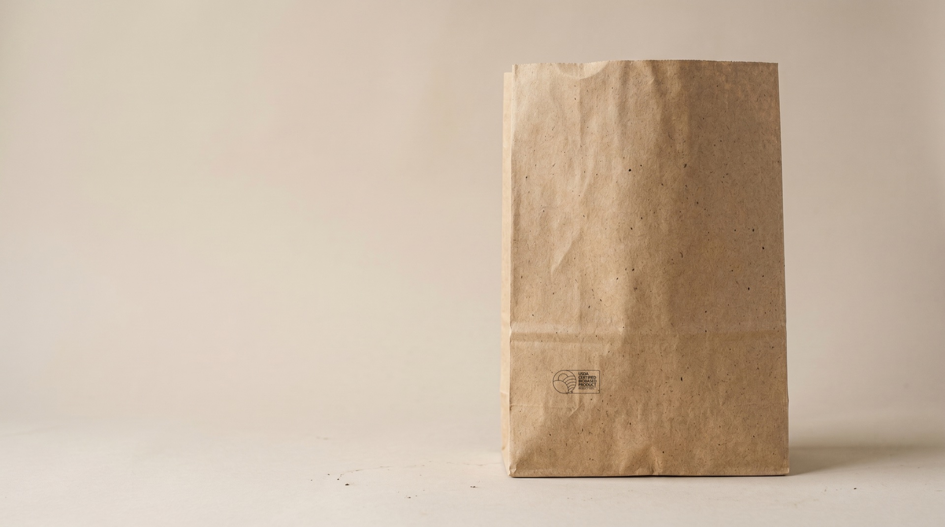 Natural kraft hemp paper SOS grocery sack with no handles and a USDA Certified Biobased stamp in the bottom corner, raw hemp-fleck paper texture